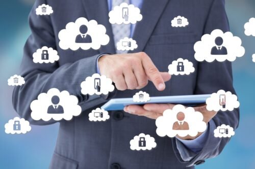 Hombre con tablet rodeado de ilustraciones de nubes con imágenes relacionadas con la seguridad informática y la contabilidad en la nube.